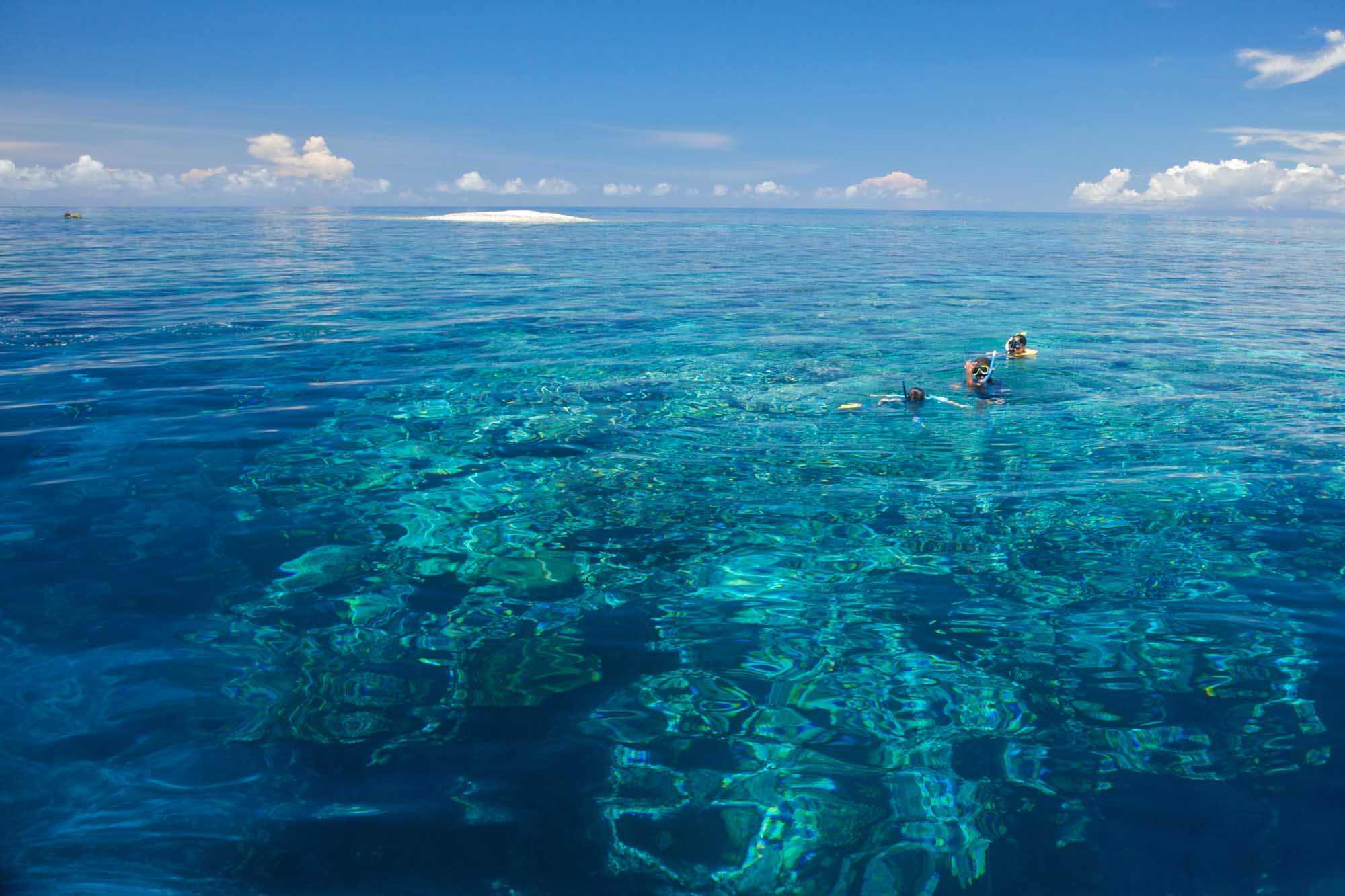 Tufi Coral Reef Diving | Sunreef Papua New Guinea Dive Expedition 2028 Snorkellers exploring crystal-clear turquoise waters above a vibrant coral reef near Tufi, Papua New Guinea, featured on Sunreef's 2028 diving expedition.